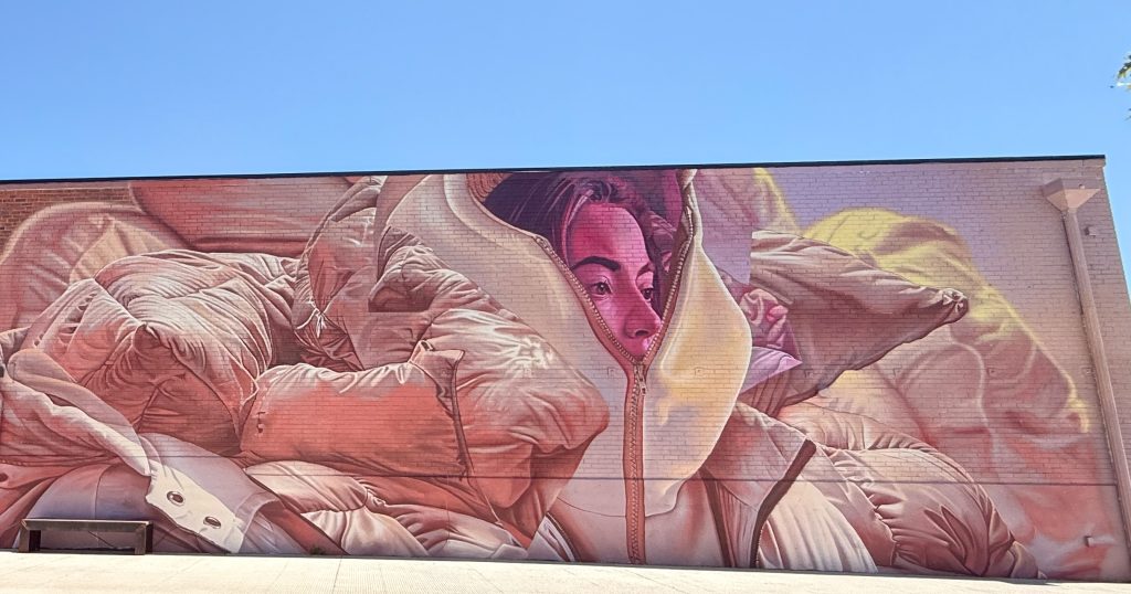 Mural by Telmo Miel of a woman wrapped in puffy jackets, RiNo Art Park, Denver